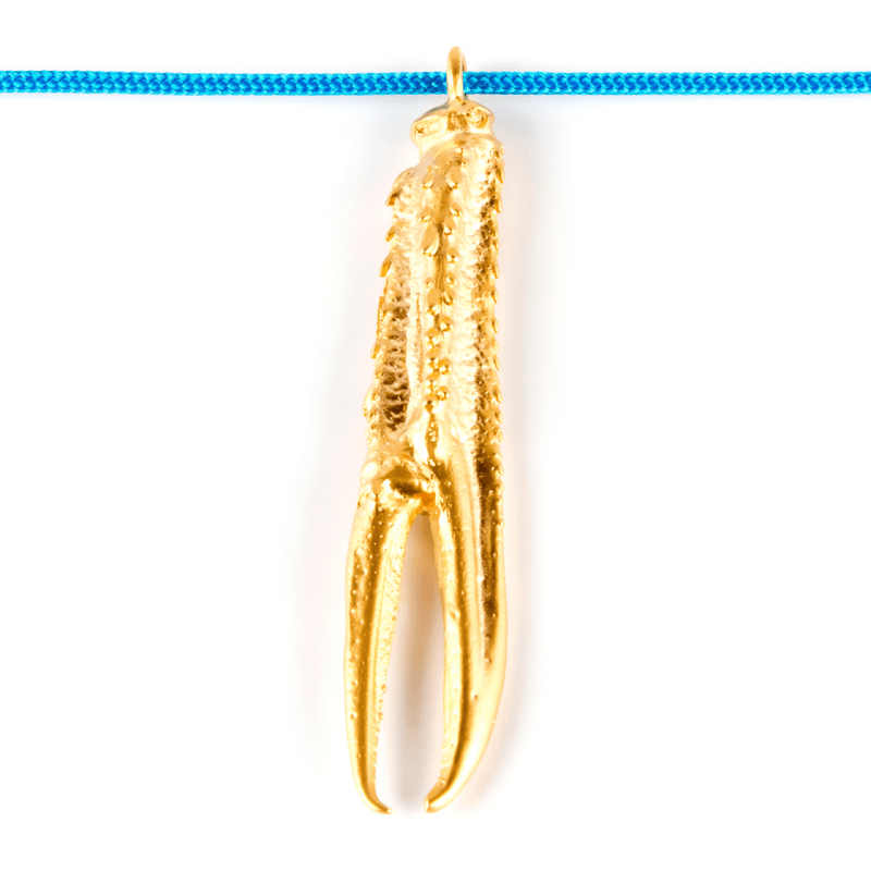 Tuent Cool, collar de nylon con pata de cigala bañada en oro.